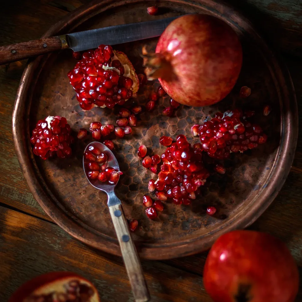 A fresh pomegranate on a cutting board, showing the concept of what's in season in Napa this winter